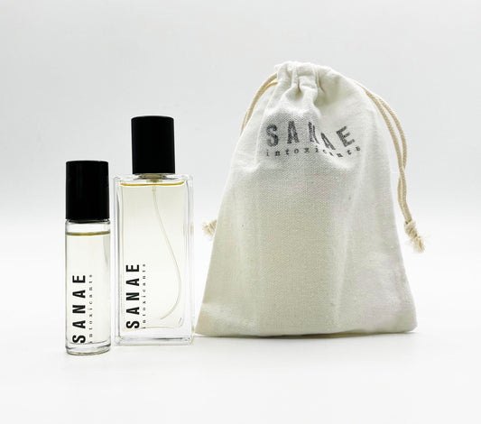Two bottles of perfume placed next to a white drawstring bag with the brand name 'SANAE intoxicants' on it.